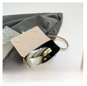 Detailed interior of the beige flap bag showing large capacity for phone and cosmetics