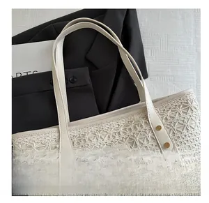Detail of woven tote bag texture with logo label and gold rivets on a smooth strap