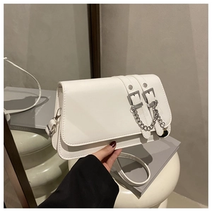 Detailed close-up of a white shoulder bag featuring decorative belts and silver buckles