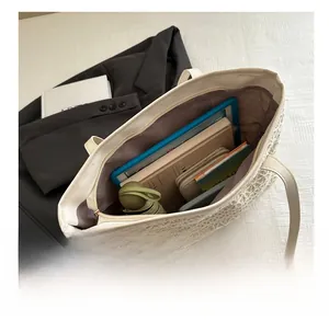 Detail showing high-capacity woven tote bag interior with books and folding umbrella