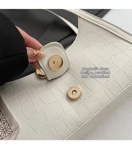 Détail du sac blanc à motif crocodile avec fermoir magnétique doré et foulard en soie