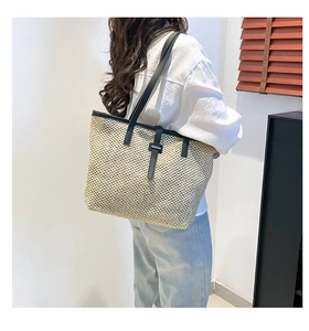 Détail du grand sac cabas en paille tressée avec bandoulières en cuir noir et texture