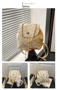 Detail eines cremefarbenen Mini-Rucksacks mit Herzsteppung, Kette und Drehverschluss