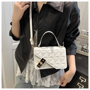 Detail of white quilted handbag with gold triangle lock and chain on a female model
