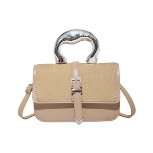 Chic beige straw patchwork handbag featuring a unique organic-shaped silver metal handle