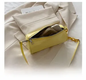 Détail du sac cylindre jaune montrant la capacité pour téléphone et portefeuille