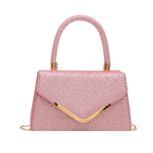 Pink sequin handbag with gold V-metal trim and chain strap shown on white background