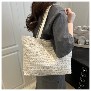 Detail of white lace tote bag featuring intricate floral patterns and JHRES & HEKA label
