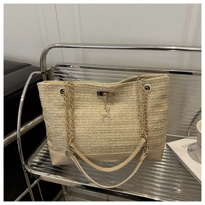 Detail of straw woven tote with wave texture, gold chain strap and deer pendant