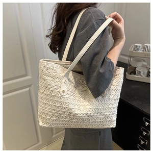 Detail view of white lace tote bag featuring intricate woven texture and leather straps