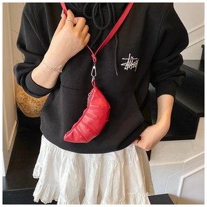 Detail der roten Crossbody-Tasche in Croissant-Form mit Faltenstruktur und Metallteilen