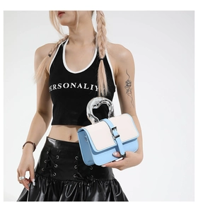 Detail of trendy color-block handbag featuring a unique fluid silver metal handle