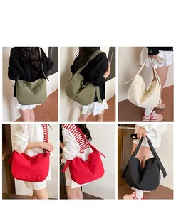 Detail view of large casual crossbody bag in green, white, red, and black colors