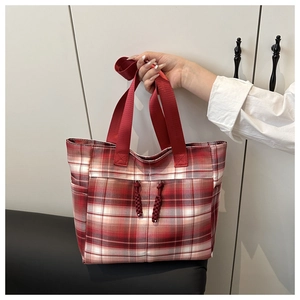 Detail of red plaid tote bag with sturdy woven handles and stylish drawstring accents
