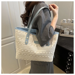 Close-up of woven tote bag featuring white crochet lace and light blue faux leather straps