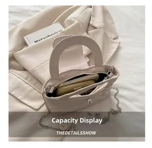 Innenraum der beigen Stepptasche mit Kettenriemen zeigt Platz für Telefon und Brieftasche