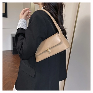 Detailed side view of a minimalist khaki baguette bag worn over the shoulder