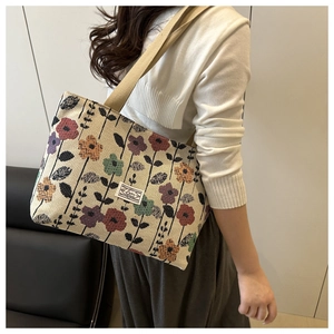 Macro view of floral knit tote bag featuring colorful jacquard patterns and logo patch