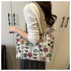 Dettaglio della borsa tote in tela intrecciata retrò con motivi floreali e manici beige