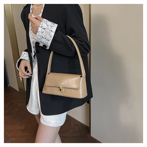 Classic khaki baguette shoulder bag with gold square metal buckle worn by a model