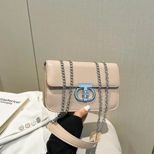 Elegante beige Umhängetasche mit silbernem Verschluss vor minimalistischem Hintergrund