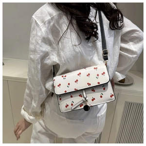 Detail of white PU crossbody bag with cherry print and adjustable black shoulder strap