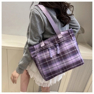 Side view of large purple checkered canvas tote bag with woven drawstring details