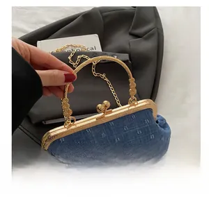 Dettaglio borsa in denim con chiusura metallica dorata, trama jacquard e catena