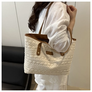 Detail of cream lace crochet tote bag with brown leather trim and branded logo patch