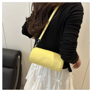 Détail du sac cylindrique jaune avec inscription Fashion & Bags et fine bandoulière