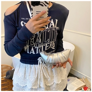 Details der silbernen Metallic-Mini-Tasche mit eleganter Faltentextur und feinem Riemen
