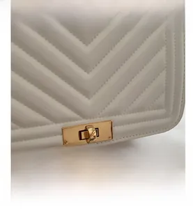 Détail de cuir blanc matelassé en chevron avec fermoir tournant doré rectangulaire