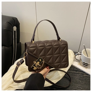 Detail of dark brown quilted crossbody bag with gold twist lock and leather texture
