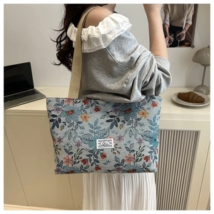 Detail view of ethnic floral jacquard tote bag with textured fabric and woven handles
