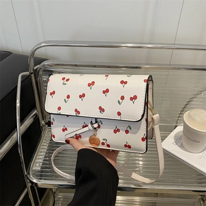 Chic white cherry print square crossbody bag for women on a stylish display