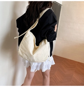 Detail of cream white tote bag showing natural wrinkled texture and wide shoulder strap