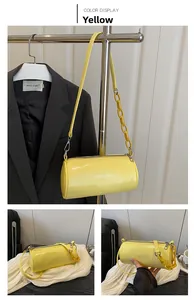 Dettaglio borsa cilindrica in pelle giallo brillante con tracolla a catena alla moda