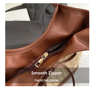 Detail of smooth metal zipper and brown pebbled leather on woven beach tote bag