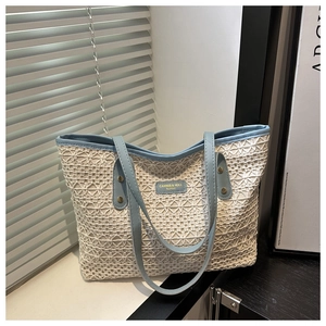 Detailed lace crochet texture on a straw-woven shoulder bag with light blue leather trim