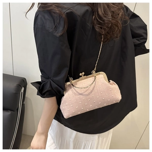Dettaglio della pochette rosa in tessuto 3D con cornice dorata e chiusura a perla