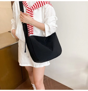 Black large capacity crossbody tote bag styled with a striped scarf for daily commute