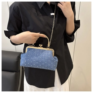 Close-up of blue denim shell bag with white polka dots and gold vintage clasp
