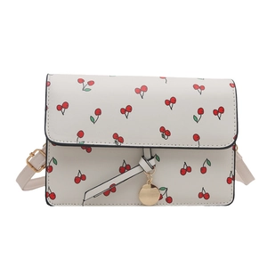 Minimalist cream square crossbody bag with red cherry pattern and gold hardware accents