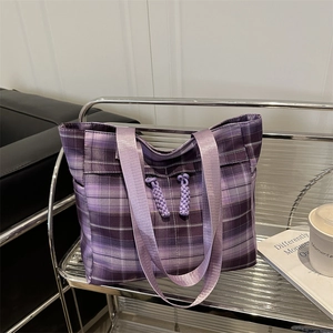 Purple plaid canvas tote bag with glossy handles displayed in a modern lifestyle setting