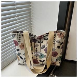 Dettaglio della grande borsa tote etnica con motivi floreali colorati e manici robusti