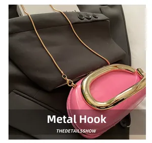 Detailed shot of pink glossy leather bag with golden chain and metallic hook fastener