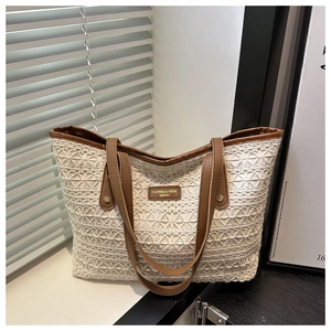 Detail of white crochet lace texture and brown leather trim on a summer tote bag