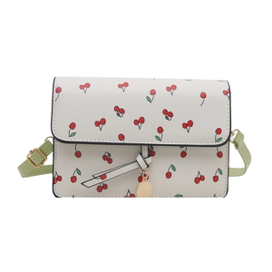 Sac bandoulière cerise blanc cassé avec bandoulière verte et pendentif en métal doré