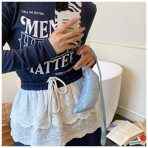 Detailansicht der hellblauen Croissant-Tasche mit weichem Faltenleder und feinen Nähten