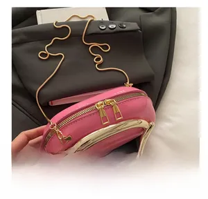 Detail of pink patent leather round clutch with golden U-shaped handle and snake chain
